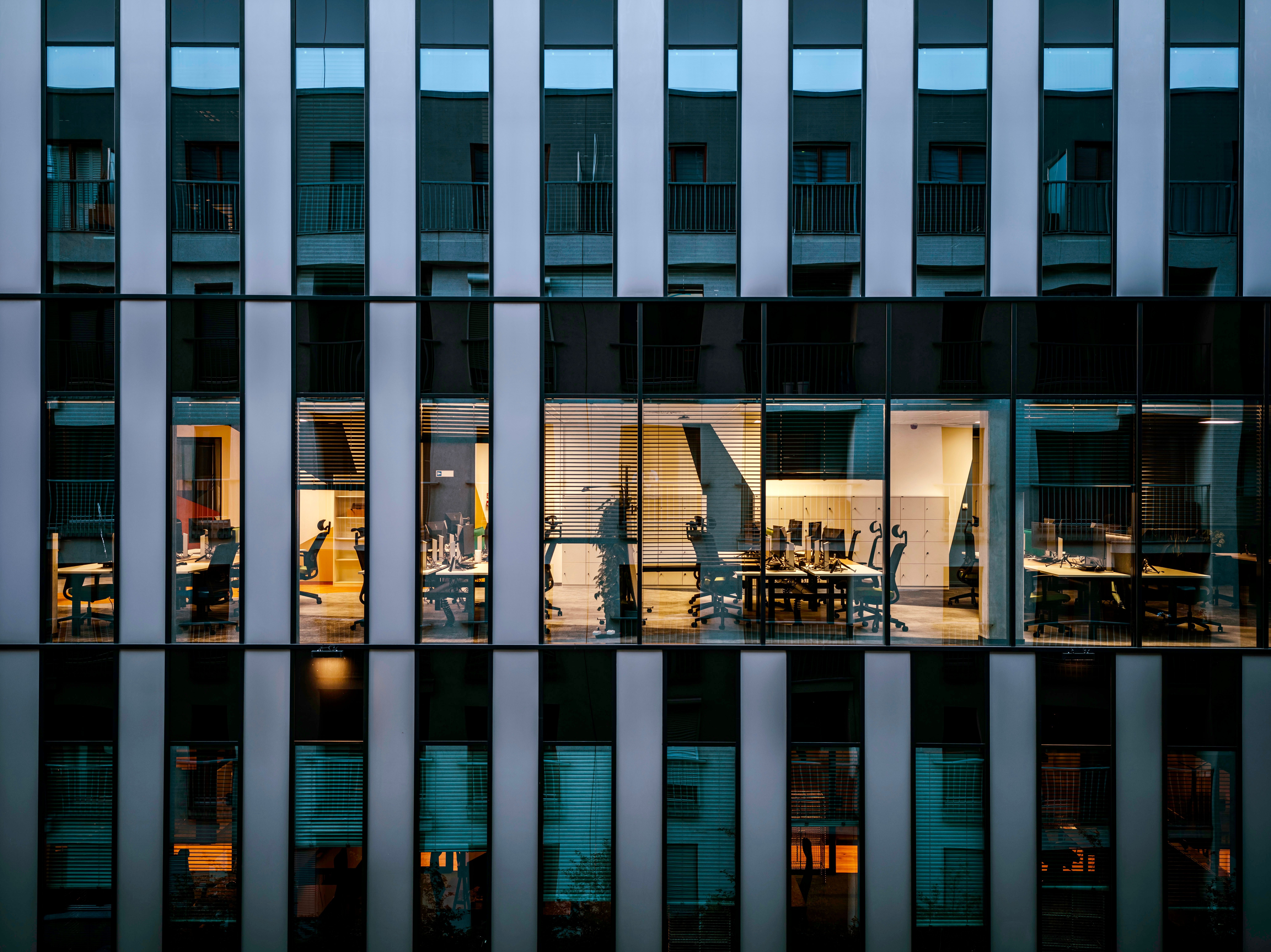 Office building exterior at dusk, workspace impact framework